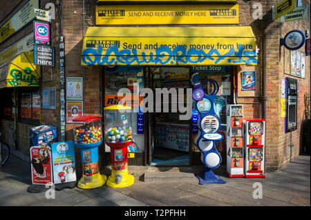 LONDON - MÄRZ 30, 2019: Schatten und Graffiti Abdeckung der Eingang zu einem Tante-Emma-Laden mit und und Lotterie Kioske und Süßigkeiten Maschinen auf Portabello Road. Stockfoto