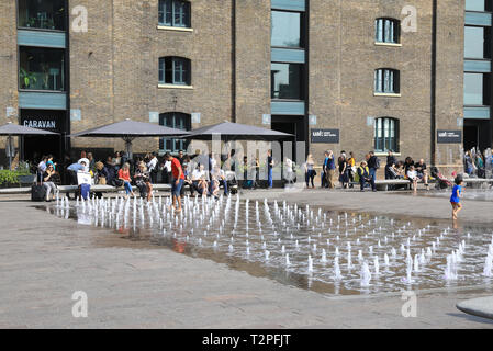 Caravan Kings Cross auf Granary Square, über die Brunnen in der Frühlingssonne, im Norden von London, Großbritannien Stockfoto