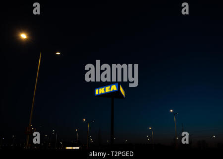 RIGA, Lettland - 3. APRIL 2019: IKEA Marke Zeichen während der dunklen Abend und wind-blauen Himmel im Hintergrund - populäre Einkaufszentrum Stockfoto