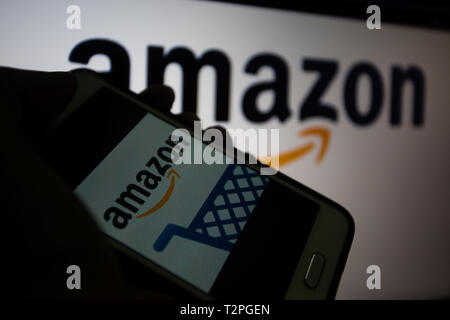 Amazon.com, amerikanischen multinationalen Technologie Unternehmen, das sich auf e-commerce, Logo wird auf dem Smartphone angezeigt, Logo unscharf im Hintergrund konzentriert sich Stockfoto