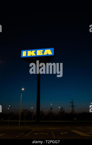 RIGA, Lettland - 3. APRIL 2019: IKEA Marke Zeichen während der dunklen Abend und wind-blauen Himmel im Hintergrund - populäre Einkaufszentrum Stockfoto