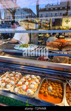 Eine Vielzahl von Speisen durch das Fenster einer Tapas Bar in der Plaza de Santa Ana zentrale Madrid gesehen. Spanien Stockfoto