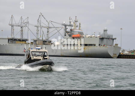 Service für Mitglieder von der in San Francisco ansässigen US Coast Guard Port Security Unit 312 an Bord eines 32-Fuß-Transportable Port Security Boot eine Sicherheitszone rund um ein Kriegsschiff in Port Hueneme, Kalifornien, während der Bereitstellung des Geräts auf die Region, in Unterstützung des Departements für Verteidigung durchsetzen - LED-Pazifik Blitz2019 Übung, 6. März 2019. Die Coast Guard bietet Kräfte auf das Verteidigungsministerium in gemeinsamen militärischen Operationen weltweit, einschließlich der Bereitstellung von Fräsern, Boote, Flugzeuge und portierbare spezialisierte Kräfte in und um die Häfen DoD kraft Mobilisierung im Th zu schützen. Stockfoto