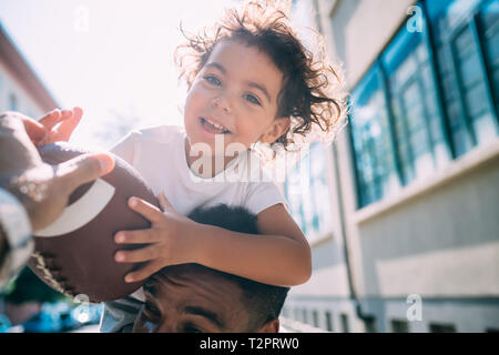 Vater und Sohn spielen mit rugby ball Stockfoto