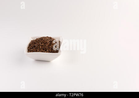 Leinsamen in der Schüssel auf weißem Hintergrund Stockfoto