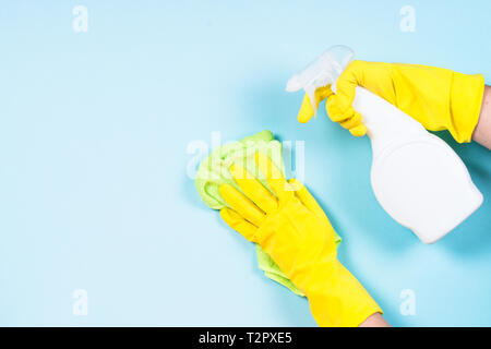 Frau Reinigung blaue Wand Microfaser mit rag und Reinigungsspray Agent. Stockfoto