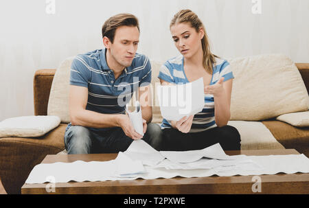 Paar Lesen eine wichtige Mitteilung in einem Brief beim Sitzen auf einem Sofa. Stockfoto