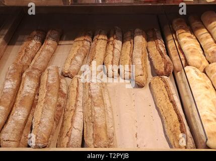 Menge frisch gebackene Hot frische und leckere Baguettes in der Storefront Regale aus verschiedenen Arten von Teig und Buchweizen Mehl Stockfoto