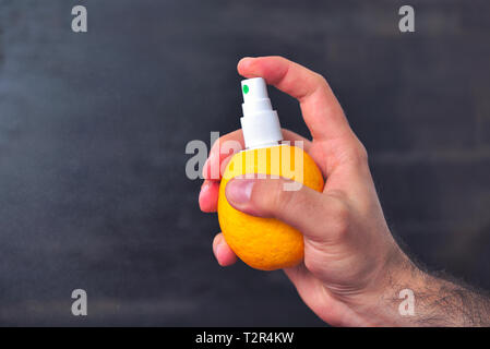 Man besprüht Saft aus der Zitrone mit Hilfe der Pumpe für Spray. Gesunde Ernährung und Vitamine. Zitronensaft spray Konzept Stockfoto