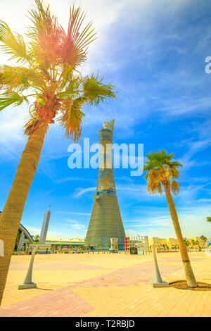 Doha, Katar - 21. Februar 2019: Aspire Tower oder die Fackel Doha, Wolkenkratzer in den Himmel mit Palmen in der Aspire Park in die Aspire Stockfoto