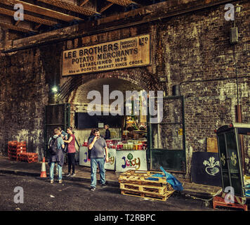 London, Großbritannien, 2018. August, urbane Szene am Borough Market mit einem alten Geschäftswerbeschild über einem Ziegelsteinbogen, England Stockfoto