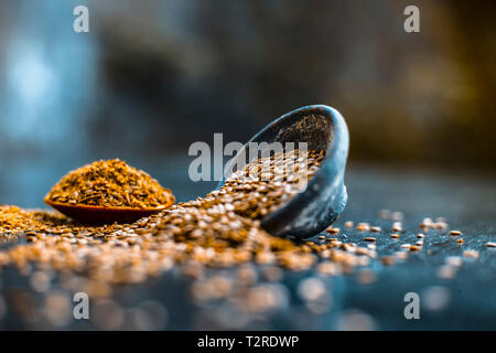 Nahaufnahme von ayurvedische Kraut Alsi oder Adsi oder Leinsamen in einer schwarz gefärbten Ton Schüssel mit dem Pulver auf Holz- Oberfläche in einem Viele ayurvedische Medizin verwendet Stockfoto