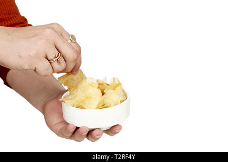 Porträt des Menschen Hand Kartoffelchips in der Schüssel. Auf den weißen Hintergrund isoliert. Stockfoto
