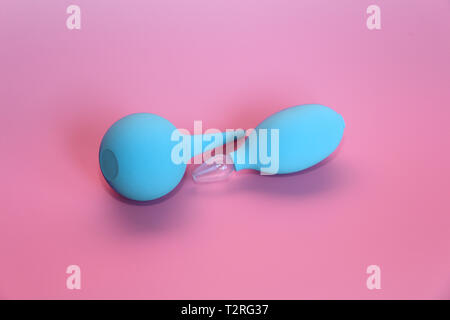 Blue enema mit einem weichen Spitze. Blau Nasensauger mit Glas Spitze. Rosa Hintergrund. Stockfoto