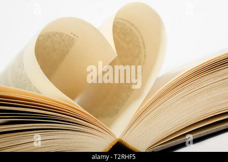 Ein offenes Buch. Beiden Seiten sind in ein Herz geformt. Gegen einen weißen Hintergrund. Stockfoto