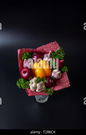 Einzigartige festlichen Strauß gelber Paprika, rote Zwiebeln, Knoblauch, Champignons und Petersilie auf einem schwarzen Hintergrund. Gemüse Bouquet. Obst und Gemüse Stockfoto