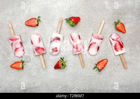 Frische Erdbeeren Eis am Stiel mit Joghurt und Erdbeeren. Ice Pop, Flach, Ansicht von oben Stockfoto