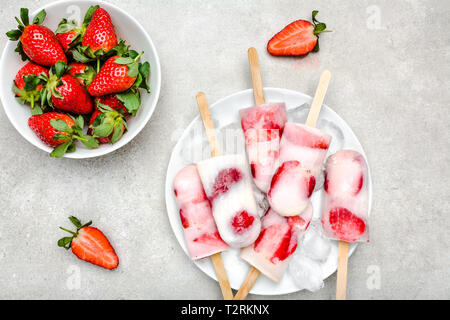 Hausgemachte Eis am Stiel mit Erdbeeren, Eis mit Milch und gefrorene Früchte Stockfoto