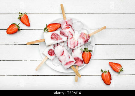 Natürliche saftige Erdbeere Eis am Stiel mit Joghurt. Erfrischendes eis Pops, Overhead, flach Stockfoto