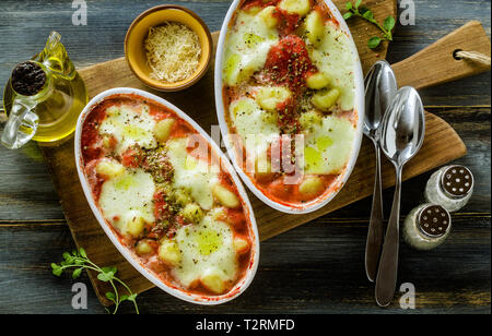 Italienischen Klöße gnocchi alla Sorrentina mit Mozzarella Käse, im Ofen gebacken mit Tomatensauce und Kräutern. Mit Parmesan und Würze serviert. Stockfoto