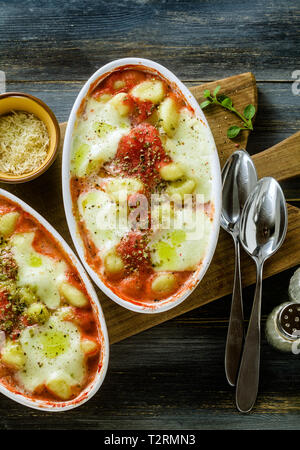 Italienischen Klöße gnocchi alla Sorrentina mit Mozzarella Käse, im Ofen gebacken mit Tomatensauce und Kräutern. Mit Parmesan und Würze serviert. Stockfoto