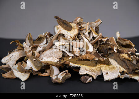 Viele Schichten von trockenen braunen Pilz Boletus Edulis. In Scheiben geschnittene getrocknete Pilze auf einem Küchentisch Stockfoto