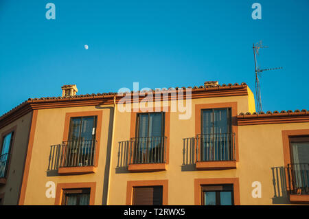 Farbenfrohes Gebäude und blauer Himmel mit einer kleinen, halbmondförmigen, Sonnenuntergang in Avila. Mit einer imposanten Mauer rund um die gotische Stadt Zentrum in Spanien. Stockfoto