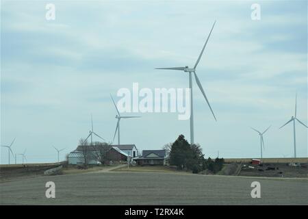 Farmen und Windkraftanlagen dot die Iowa Landschaft Stockfoto