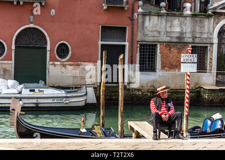 Gondoliere gekleidet in traditionelle rot gestreiften Oberteil und Strohhut mit roter Schleife in Venedig, Italien Stockfoto