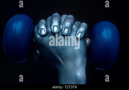 Nahaufnahme der gekreuzten Hände halten eine Hantel (Bodypainting) Stockfoto