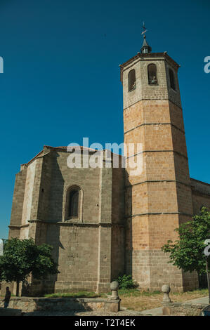 Glockenturm der Kirche aus Ziegel und grüne Bäume mit blauen Himmel bei Avila. Mit einer imposanten Mauer rund um die gotische Stadt Zentrum in Spanien. Stockfoto