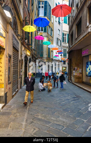 Genua, Italien - Oktober 14, 2018: bunte Sonnenschirme geöffnet auf schmalen Straße in der Altstadt Stockfoto