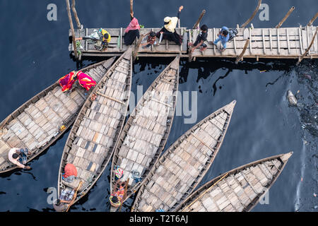 Nicht erkennbare muslimischen Familie ist immer auf dem Boot zu überqueren, schwarze Wasser des Flusses Buriganga, Dhaka, Bangladesch, oben Luftbild Stockfoto