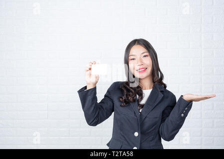 Business Frau mit einem separaten Cash Card, weiße Mauer machte Gesten mit Gebärdensprache. Stockfoto