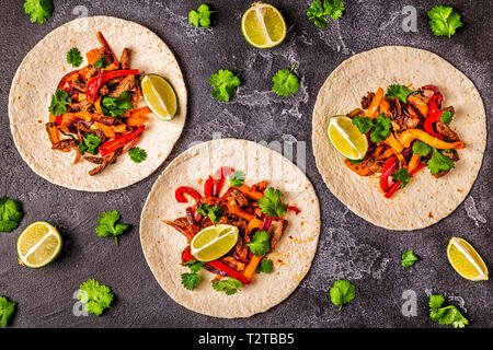 FAJITAS mit buntem Pfeffer und Zwiebeln, serviert mit Tortillas, Salsa und saure Sahne. Stockfoto