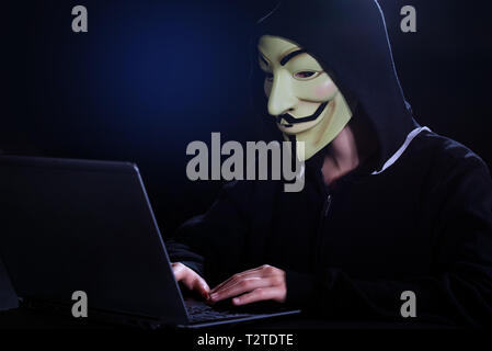 Triest, Italien, 08. November 2018. Eine indifinited Person mit anonymen Maske und Notebook. Konzept der Informatik Sicherheit, Widerstand und c Stockfoto