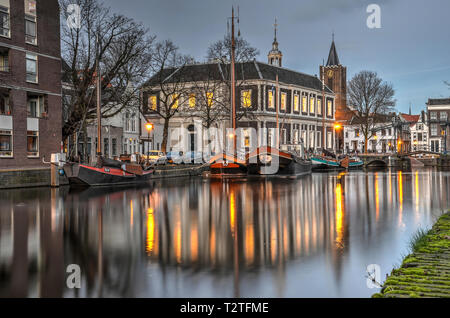 Schiedam, Niederlande, 11. Februar 2019: Blick auf den Kanal. Diese heißen "Kurze Hafen in der Blauen Stunde, mit historischen Lastkähne und der ehemaligen Corn Exchange Stockfoto