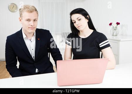 Vorgesetzten arbeitet mit unterordnen. Blonder Mann arbeiten mit schwarzhaarige Frau, Arbeitsbeziehungen Stockfoto
