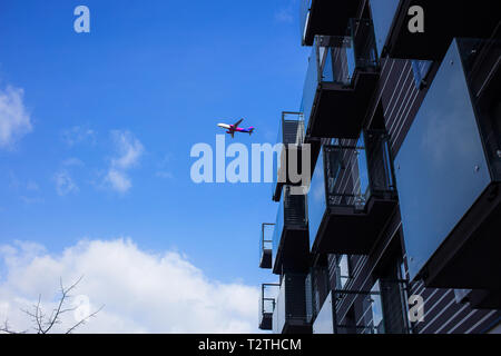 Poznan - Polen/16. März 2019, Flugzeug fliegt über neue Luxus Apartment Gebäude in einem der letzten Flüge und der Ungarische Billigflieger Wizz Air Stockfoto