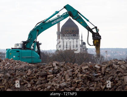 Dresden, Deutschland. 25 Mär, 2019. Ein Bagger ist besetzt mit Abbrucharbeiten auf dem zukünftigen Gebäude der "Hafencity" in Dresden, im Hintergrund sehen Sie die Yendize, das ehemalige Fabrikgebäude der Zigarettenfabrik. (Dpa' auf dem Weg nach Berlin? - Demos gegen die Mieten erhöhen") Credit: Robert Michael/dpa-Zentralbild/dpa/Alamy leben Nachrichten Stockfoto