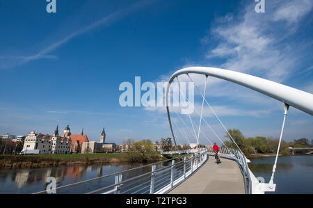 04 April 2019, Sachsen-Anhalt, Dessau-Roßlau: ein Radfahrer kreuzt die Mulde vor dem Johannbau der ehemaligen Stadt Schloss von Dessau. Der Frühling ist Erwachen alles rund um das Bauhaus Stadt. Foto: Hendrik Schmidt/dpa-Zentralbild/dpa Stockfoto