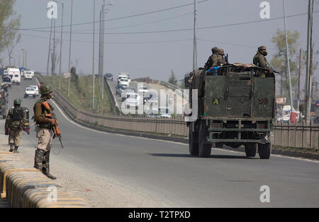 Srinagar, Kashmir. 4 Apr, 2019. Indische paramilitärischen troopers stand Guard als Armee Fahrzeug auf einer Autobahn in der Nähe von Srinagar, Kashmir, April 4, 2019. Behörden in Kaschmir sagte am Mittwoch, dass keine zivilen Verkehr erlaubt sein würde, auf der Autobahn in die widerspenstige Region für zwei Tage in der Woche im Hinblick auf die große Bewegung der Regierung Kräfte zu Ply während der allgemeinen Wahlen in der kommenden Indien. Credit: Javed Dar/Xinhua/Alamy leben Nachrichten Stockfoto