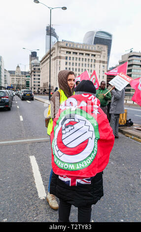 London, UK, 04. April 2019. Minicab Treiber Block die Straße auf die London Bridge protestieren gegen die Verkehrsüberlastung auf private Hire minicabs. Dieser Demonstrator ist in die rote Fahne der IWGB (Unabhängige Gewerkschaft in Großbritannien) gewickelt. Credit: Graham Prentice/Alamy leben Nachrichten Stockfoto