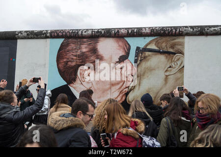 Touristen an der 'Mein Gott, hilf mir, diese tödliche Liebe" (oder "brüderliche Kuss') Wandmalerei von Dimitri Vrubel an der East Side Gallery in Berlin um zu überleben Stockfoto