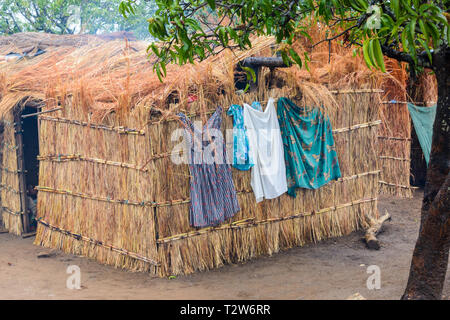 Kleidung der Frauen hing an der Seite des Gras ummauerten und überdachte Gebäude in Malawischen Dorf zu trocknen Stockfoto
