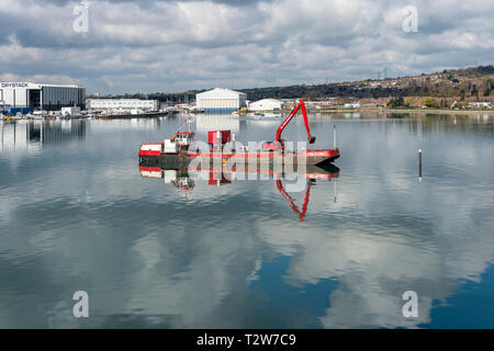 Schwimmbagger und digger Clearing einen Kanal in Portsmouth Harbour Stockfoto