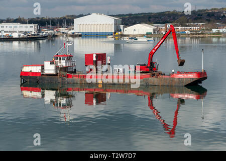 Schwimmbagger und digger Clearing einen Kanal in Portsmouth Harbour Stockfoto