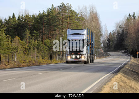 Salo, Finnland - Dezember 21, 2018: Silber Scania R730 Streamline logging Truck Transport eine Björkqvist auf ländlichen Straßen mit Fernlicht kurz auf. Stockfoto