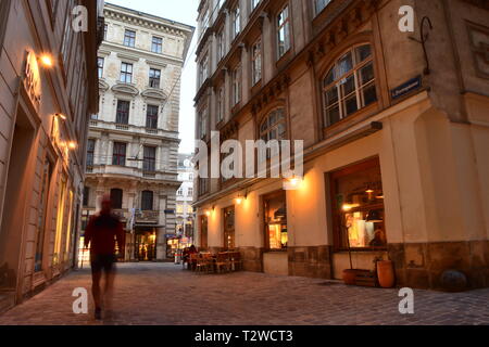 Domgasse, engen, kopfsteingepflasterten Straße mit historischen barocken Häuser der Altstadt von Wien. Abendstimmung mit Passanten und ein Cafe. Stockfoto
