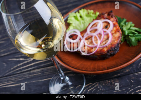 Ein Glas Weißwein halbtrocken Wein mit Steak im Restaurant. Stockfoto